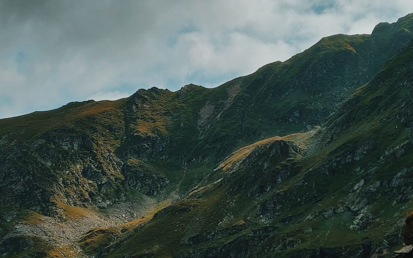 A winding pass road climbing through Swiss mountains