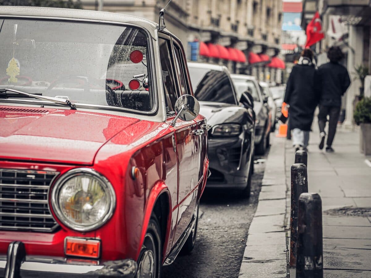 A red vintage Japanese saloon parked on a city street
